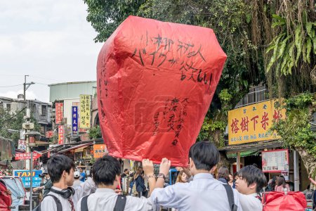 Foto de Shifen, Pingxi, Taiwán- 15 de noviembre de 2018: Las personas que lanzan Sky Lanterns con deseos escritos en él en la antigua calle Shifen, distrito de Pingxi, Taiwán. Shifen es un pequeño pueblo a una hora de Taipei - Imagen libre de derechos