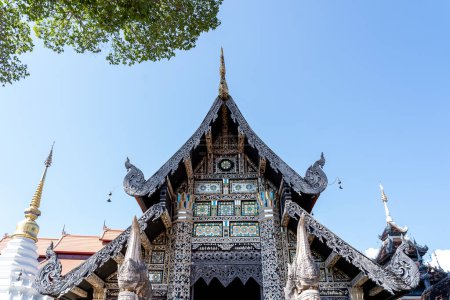 Téléchargez les photos : Tympan traditionnel en bois de style thaïlandais décoré avec un beau motif de vitrail coloré au-dessus d'une entrée dans le temple Buddhsit Chiengmai, Thaïlande 15 janvier 2020 - en image libre de droit
