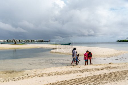 Téléchargez les photos : Famille reposant sur la côte de la plage - en image libre de droit