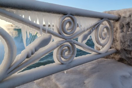 Foto de Barandilla de hierro decorativa cubierta de hielo con caídas en el fondo, Cataratas del Niágara, Ontario, Canadá - Imagen libre de derechos