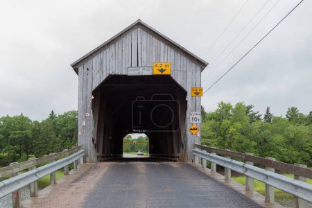 Téléchargez les photos : NOUVEAU-BRUNSWICK, CANADA - 5 août 2017 : ruisseau de la scierie no. 0,5 pont couvert au Nouveau-Brunswick, Canada. Construit en 1908, ce pont couvert mesure 33 m de long.. - en image libre de droit