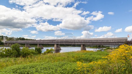 Téléchargez les photos : NOUVEAU-BRUNSWICK, CANADA - Le 6 août 2017 : Vue latérale du pont couvert de Hartland au Nouveau-Brunswick. Ce pont de 390 m (1 282 pi) a ouvert ses portes en 1901, le plus long pont couvert de bois au monde.. - en image libre de droit