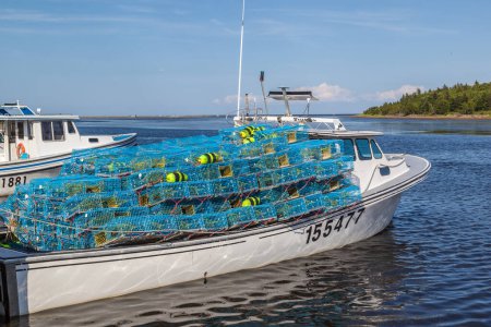 Téléchargez les photos : NOUVEAU-BRUNSWICK, CANADA - Le 5 août 2017 : Une pile de casiers à homard bleus chargés sur le bateau est prête à partir pour la nouvelle saison du homard. - en image libre de droit