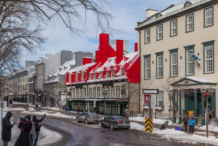 Foto de CIUDAD DE QUEBEC, CANADÁ 14 de febrero de 2016: Antiguo restaurante de techo rojo en la ciudad de Quebec, Canadá. Quebec es uno de los asentamientos europeos más antiguos de América del Norte. - Imagen libre de derechos