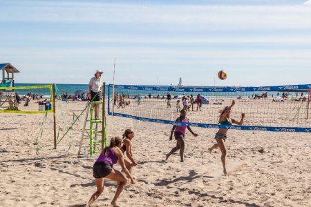 Téléchargez les photos : COBOURG, ONTARIO, CANADA - LE 10 JUILLET 2016 : Quatre femmes jouant au volleyball de plage lors d'une compétition tenue à Victoria Beach à Cobourg, Ontario, le 10 juillet 2016. - en image libre de droit