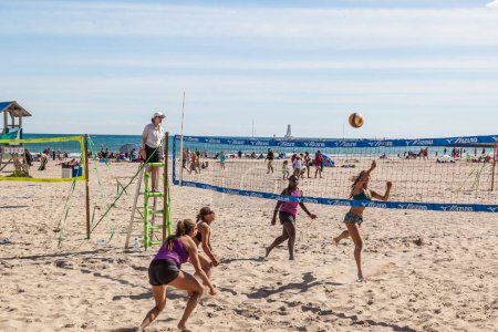 Téléchargez les photos : COBOURG, ONTARIO, CANADA - LE 10 JUILLET 2016 : Quatre femmes jouant au volleyball de plage lors d'une compétition tenue à Victoria Beach à Cobourg, Ontario, le 10 juillet 2016. - en image libre de droit