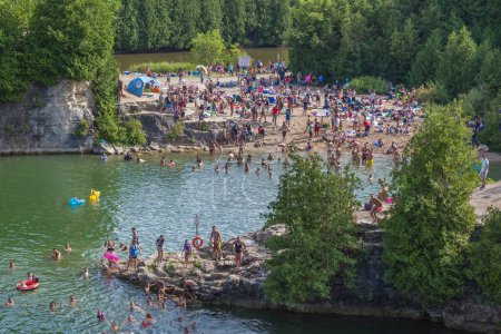 Photo for ELORA, ONTARIO, CANADA - JULY 30, 2016: People swimming in Elora Quarry conservation area. Known as old swimming hole, this two acre former limestone quarry is encircled by 12 m high sheer cliffs. - Royalty Free Image