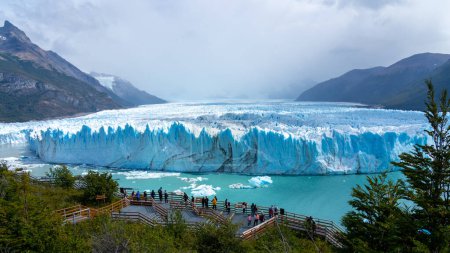 Foto de Santa Cruz, Argentina - 4 de febrero de 2023: Turistas observando el glaciar en las pasarelas en el Glaciar Perito Moreno del Parque Nacional Los Glaciares en Argentina. - Imagen libre de derechos