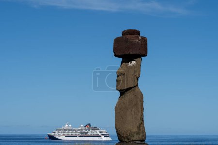 Téléchargez les photos : Île de Pâques, Chili - 5 mars 2023 : La statue de moai avec coiffure et yeux de corail restaurés sur Ahu Ko Te Riku avec un bateau de croisière en arrière-plan au complexe Ahu Tahai. Île de Pâques (Rapa Nui), Chili - en image libre de droit