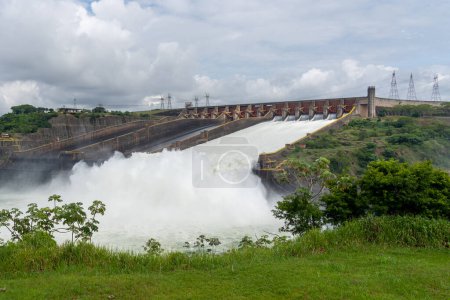 Foto de Foz do iguacu, Brasil - 15 de enero de 2023: El vertedero de la presa de Itaipú es visto desde el centro de visitantes cerca de Foz do iguacu, Brasil. Presa Itaipú es una presa hidroeléctrica en la frontera entre Brasil y Paraguay. - Imagen libre de derechos