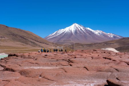 Téléchargez les photos : Red Rocks (Piedras Rojas), lagune et salines avec des touristes méconnaissables dans le désert d'Atacama, Chili. Ces paysages volcaniques sont situés au cœur de l'altiplano chilien. - en image libre de droit