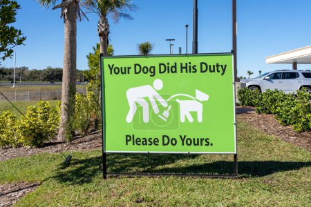 A notice sign with the words Your Dog Did His Duty, Please Do Yours on the ground.
