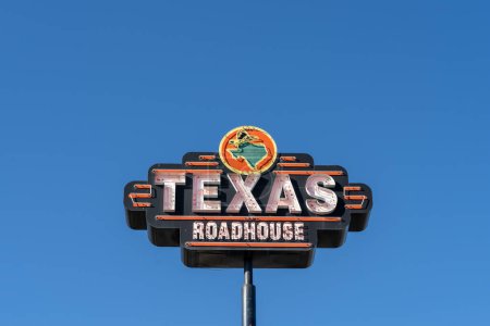 Foto de Señal de carretera de Texas Roadhouse contra un fondo azul del cielo - Imagen libre de derechos