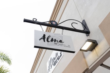 Téléchargez les photos : Orlando, Floride, États-Unis - janvier 21, 2022 : Alma store hanging sign is shown. Alma by Angel De La Guarda propose des maillots de bain élégants, des couvertures et des accessoires de plage pour femmes. - en image libre de droit
