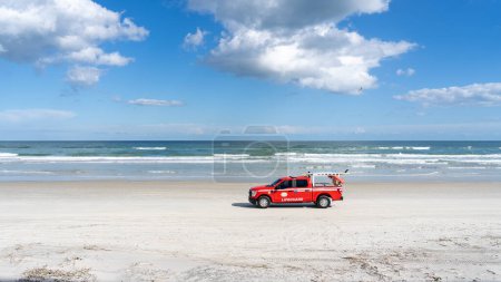 Téléchargez les photos : Daytona Beach, Floride, États-Unis - 31 février 2022 : Un camion de sauveteur conduisant sur Daytona Beach, Floride, États-Unis. Daytona Beach a du sable dur où la conduite est autorisée dans les zones désignées. - en image libre de droit