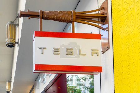 Téléchargez les photos : Honolulu, HI, États-Unis - 14 janvier 2024 : Gros plan sur le logo de Tesla accroché dans leur showroom dans un centre commercial à Waikiki, Hawaï. Tesla, Inc. est une entreprise américaine d'automobile et d'énergie propre. - en image libre de droit