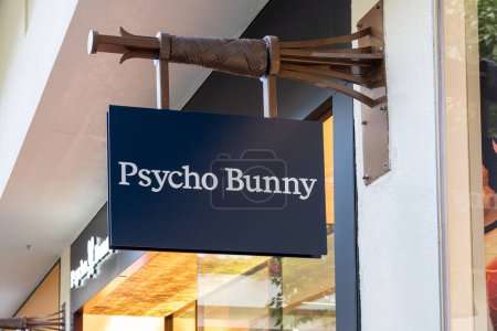 Foto de Honolulu, HI, Estados Unidos - 14 de enero de 2024: Cartel de Psycho Bunny colgado en su tienda en un centro comercial en Waikiki, Hawaii. Psycho Bunny es una empresa privada de ropa para hombres. - Imagen libre de derechos