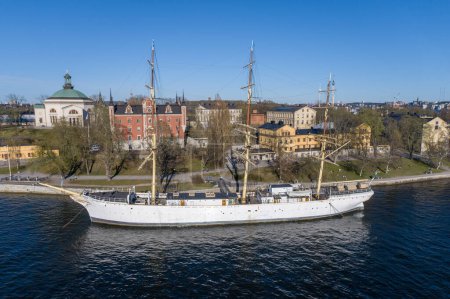 Photo for Af Chapman and Admiralty House. Full-rigged Steel Ship Moored on the Western Shore of the Islet Skeppsholmen in Central Stockholm, Sweden, Now Serving as a Youth Hostel - Royalty Free Image