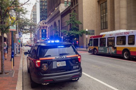 Photo for Baltimore, Maryland - October 03, 2019: Baltimore Police Vehicle with Flashing Lights On. Cityscape in Background. - Royalty Free Image