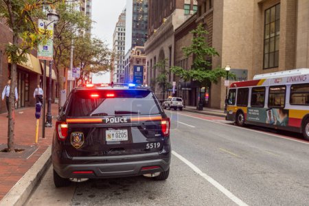 Téléchargez les photos : Baltimore, Maryland - October 03, 2019: Baltimore Police Vehicle with Flashing Lights On. Cityscape in Background. - en image libre de droit