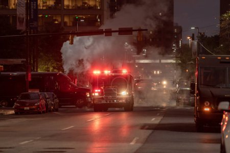 Foto de Tráfico nocturno en Baltimore, Maryland. Vehículos y vehículos del Departamento de Bomberos con luces intermitentes en segundo plano. - Imagen libre de derechos