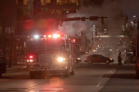 Téléchargez les photos : Night Traffic in Baltimore, Maryland. Vehicles and Fire Department Vehicle with Flashing Lights in Background. - en image libre de droit