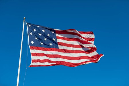 Foto de USA Flag Waving in Blue Background. Clear Blue Sky. American Wave Flag - Imagen libre de derechos