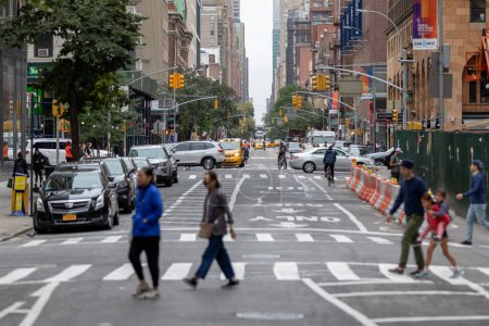 Foto de Manhattan, Nueva York - 06 de octubre de 2019: Paisaje urbano con tráfico y calle. Manhattan. Semáforos amarillos en segundo plano. Gente cruzando la calle. - Imagen libre de derechos