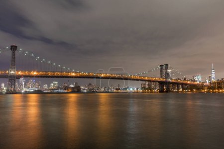 Photo for The Williamsburg Bridge is a suspension bridge in New York City across the East River connecting the Lower East Side of Manhattan at Delancey Street with the Williamsburg neighborhood of Brooklyn - Royalty Free Image