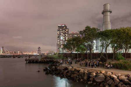 Téléchargez les photos : Brooklyn, NYC - October 07, 2019: Hasidic Jews from the Williamsburg neighborhood of Brooklyn, New York at the shore of the East River. Blurry Because of Long Exposure - en image libre de droit