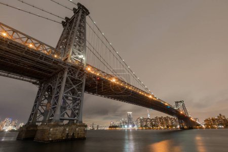Photo for The Williamsburg Bridge is a suspension bridge in New York City across the East River connecting the Lower East Side of Manhattan at Delancey Street with the Williamsburg neighborhood of Brooklyn - Royalty Free Image