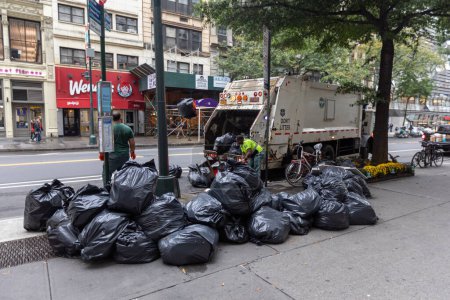 Photo for Manhattan, NYC - October 08, 2019: DSNY workers collect trash on a city street. New York Department of Sanitation is responsible for garbage - Royalty Free Image