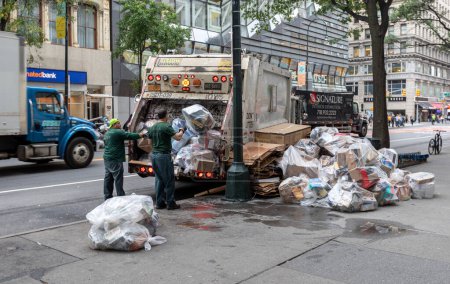 Foto de Manhattan, Nueva York - 08 de octubre de 2019: Los trabajadores de DSNY recogen basura en una calle de la ciudad. Departamento de Saneamiento de Nueva York es responsable de la basura - Imagen libre de derechos