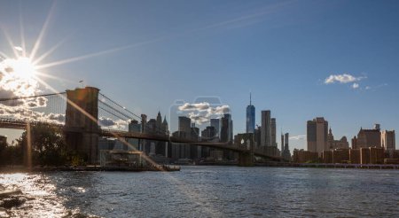Photo for Brooklyn Bridge, East River and Lower Manhattan in Background. NYC Skyline. Bright Sunny Day and Sunlight. Dumbo. Sightseeing Place Among Locals and Tourists in NYC. - Royalty Free Image