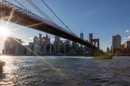 Photo for Brooklyn Bridge, East River and Lower Manhattan in Background. NYC Skyline. Bright Sunny Day and Sunlight. Dumbo. Sightseeing Place Among Locals and Tourists in NYC. - Royalty Free Image