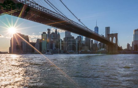 Téléchargez les photos : Brooklyn Bridge, East River et Lower Manhattan en arrière-plan. NYC Skyline. Lumineux jour ensoleillé et lumière du soleil. Dumbo. Lieu de visite parmi les habitants et les touristes à New York. - en image libre de droit