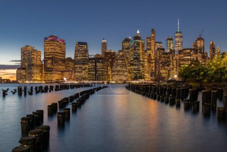 Téléchargez les photos : Paysage urbain de New York au coucher du soleil. Vieille jetée au premier plan. Lower Manhattan Cityscape in Background. Gratte-ciel - en image libre de droit