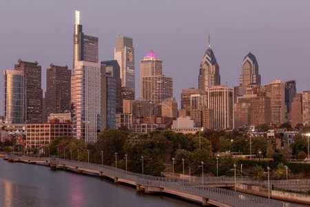 Photo for Philadelphia Downtown skyline with the Schuylkill river. Beautiful Sunset Light. Schuylkill River Trail in Background. City skyline glows under the beautiful sunset light. PA, USA. - Royalty Free Image