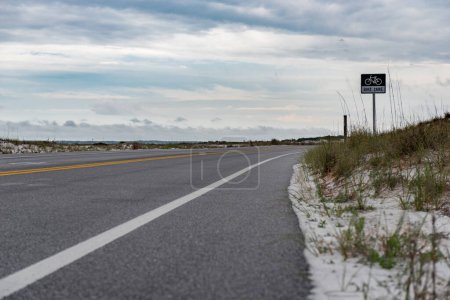 Foto de Bike Line Sign In Pensacola. Empty Road and Cloudy Sky. USA. Florida - Imagen libre de derechos