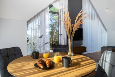 Téléchargez les photos : The Stylish Spacious Luxury Interior Design of Living Room with Coffee Table and Croissant Breakfast, Decoration in Modern Home Decor - en image libre de droit