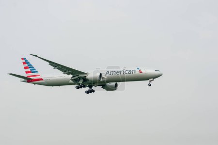 Foto de American Airlines Boeing 777 N718AN aterrizaje en el Aeropuerto Internacional de Londres Heathrow. - Imagen libre de derechos