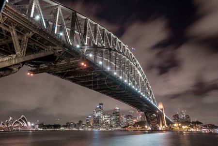 Foto de Sydney Harbour Bridge y Opera House por la noche. Hermoso paisaje urbano de Sydney y Skyline. Larga exposición. Cielo que fluye. Países Bajos - Imagen libre de derechos