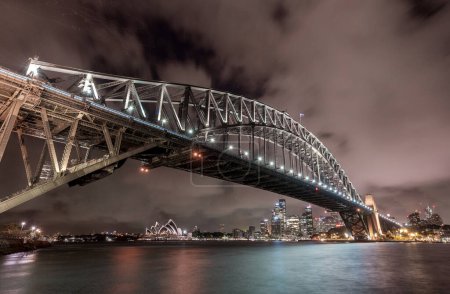 Foto de Sydney Harbour Bridge and Opera House at Night. Beautiful Sydney Cityscape and Skyline. Long Exposure. Flowing Sky. Australia - Imagen libre de derechos