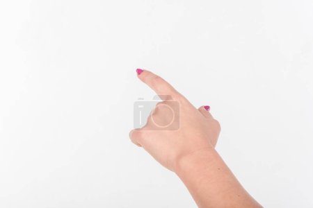 Téléchargez les photos : Main de femme avec les doigts polonais sur fond blanc. Montre signe et geste vers - en image libre de droit