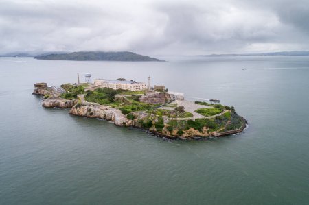 Téléchargez les photos : Aerial view of Alcatraz island in the San Francisco Bay. USA. The most famous Alcatraz Prison, Jail. Sightseeing Place. San Francisco Cityscape in Background. - en image libre de droit