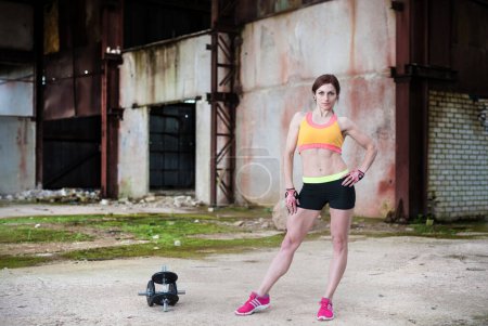 Photo for Fitness Girl Young Beautiful Woman Doing Exercises with Dumbbell in Abandoned Building. - Royalty Free Image