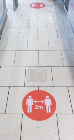 Photo for Covid19 Sign in Shopping Mall. Social Distancing Between People is Requiring in Public Places - Royalty Free Image