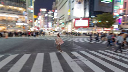 Téléchargez les photos : TOKYO, JAPAN - OCTOBER 30, 2019: Shibuya Crossing in Tokyo, Japan. The most famous intersection in the world. Blurry beacause of the panning. - en image libre de droit