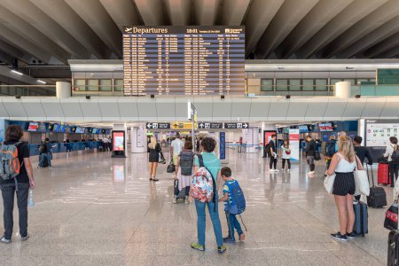 Photo for ROME, ITALY - OCTOBER 22, 2019: Rome international Leonardo da Vinci Fiumicino Airport interior with people. Departure area with departure screen. - Royalty Free Image
