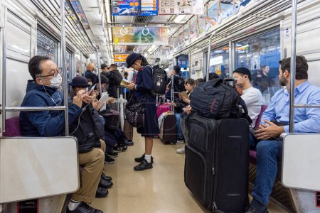 Foto de TOKYO, JAPAN - OCTOBER 24, 2019: Full People of Tokyo Train Car. People are traveling from airport to Tokyo City.  Keisei Main Line Rapid Limited Express - Imagen libre de derechos